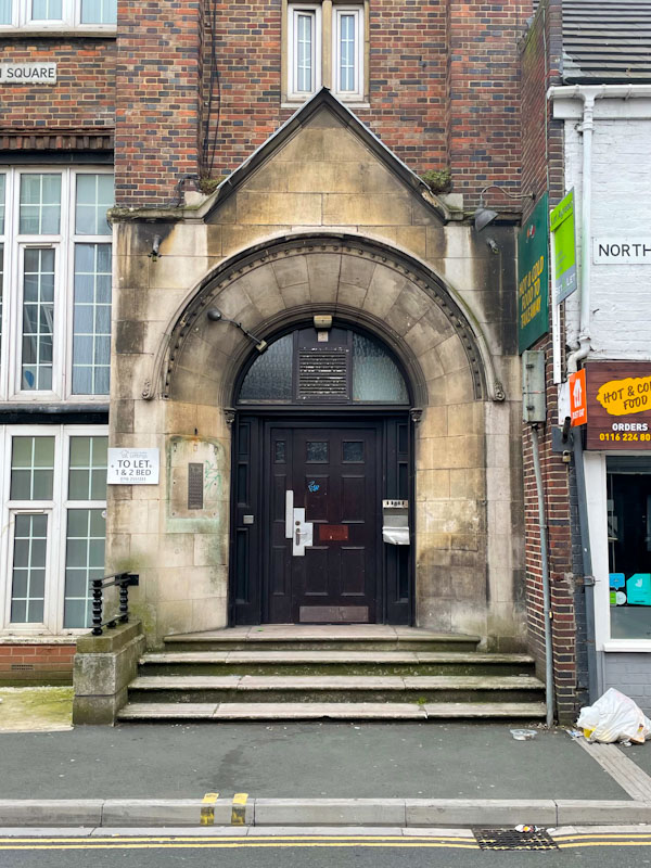 Fancy doorway with as utilitarian door, Leicester, Leicestershire, May 2024