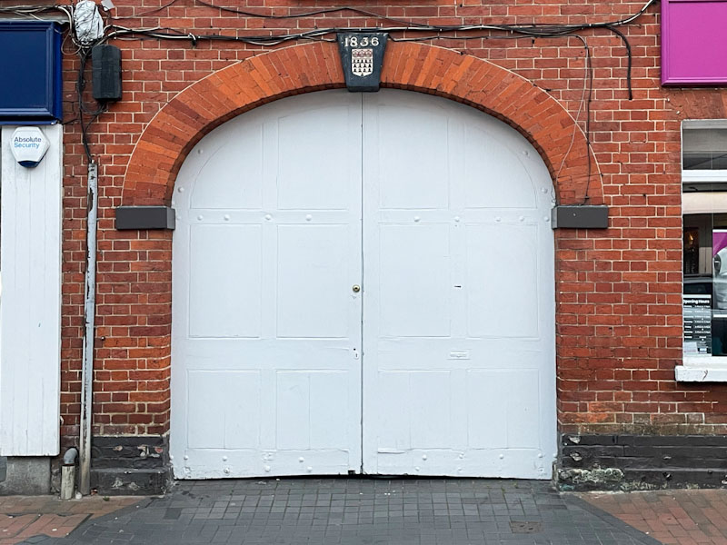 Yard double door and archway dated 1836, High Street, Godalming, Surrey, March 2025