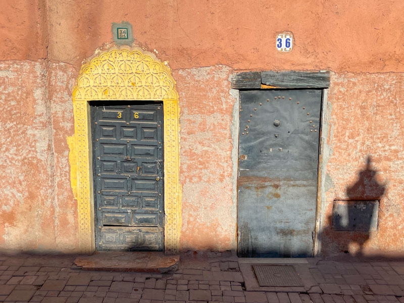 A pair of markedly different doors side by side and a lamp shadow, Derb Oualidine, Marrakesh, Morocco, January 2025