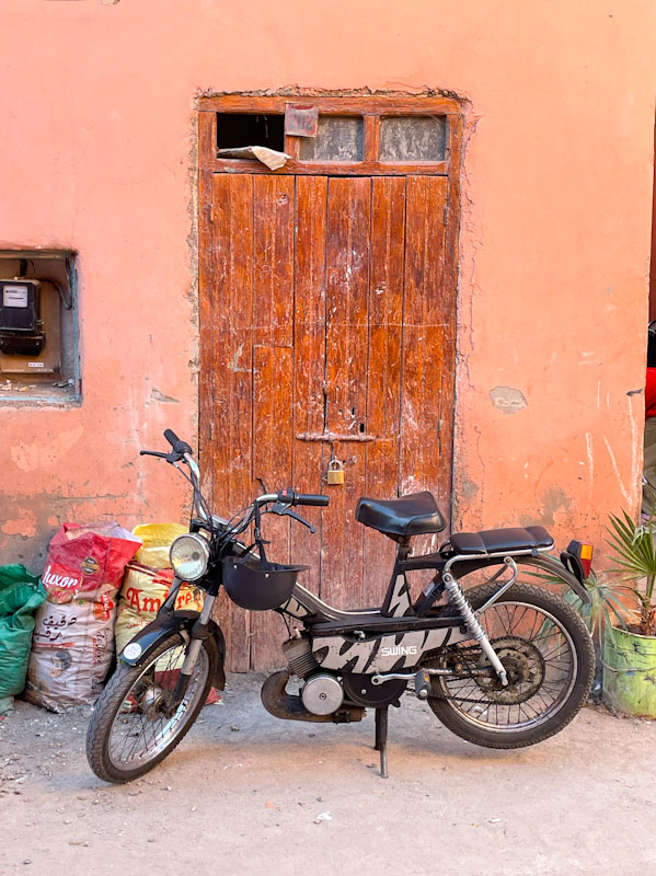 Plain door with bold and padlock and motorcycle, Tariq Makhzen, Marrakesh, Morocco, January 2025