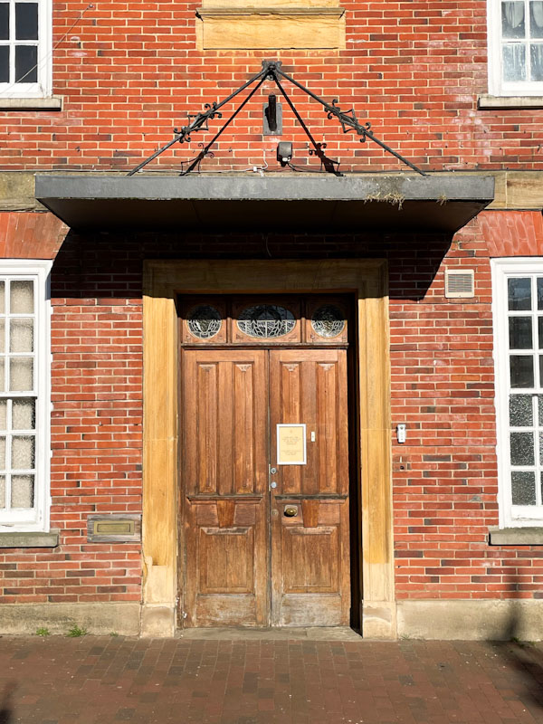 An unusual door with a suspended canopy, Bridge Street, Godalming, Surrey, March 2025