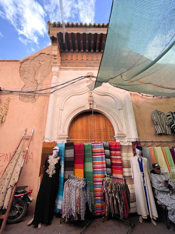Market stall in front of a magnificent large door, Rue Riad Zitoun El Jedid, Marrakesh, Morocco