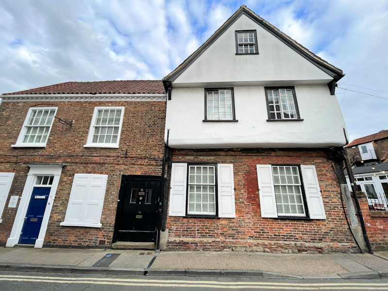 Wide black door and blue door, York, North Yorkshire, June 2024