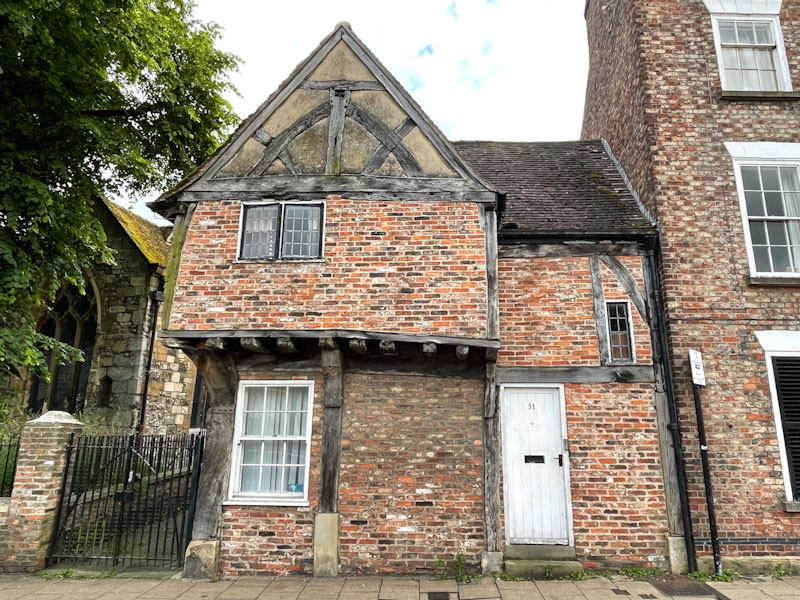 White door of a brick and timber framed house, York, North Yorkshire, June 2024
