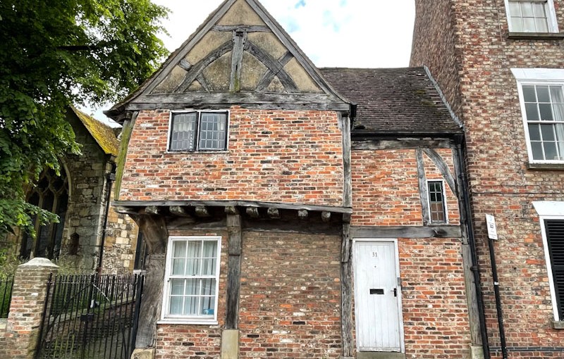 White door of a brick and timber framed house, York, North Yorkshire, June 2024