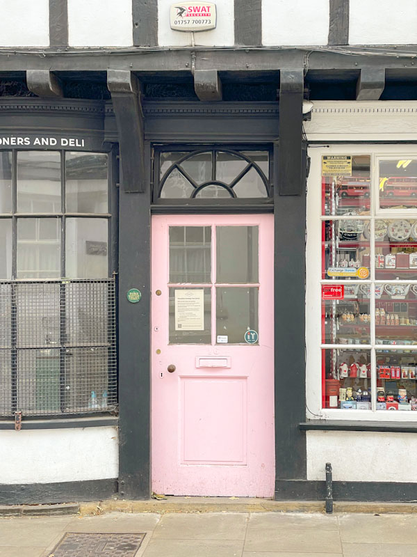 Pink shop door, York, North Yorkshire, June 2024