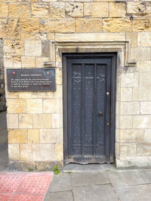 Door and plaque marking the site of the Roman North West Gate, York, North Yorkshire, June 2024