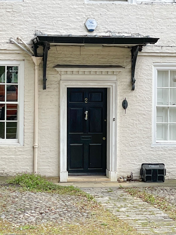 Black door and flat awning, York, North Yorkshire, June 2024