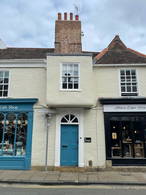 Blue door and protruding window, Goodramgate, York, North Yorkshire, June 2024