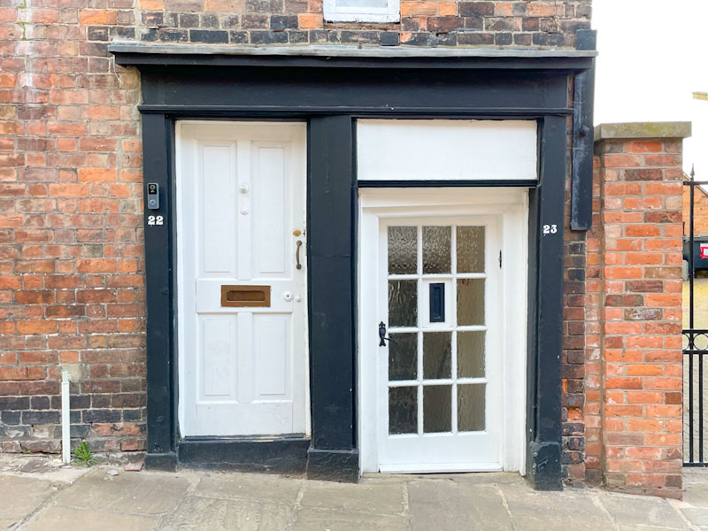 A pair of quite different doors sharing a black frame, Claremont Hill, Shrewsbury, Shropshire, April 2025