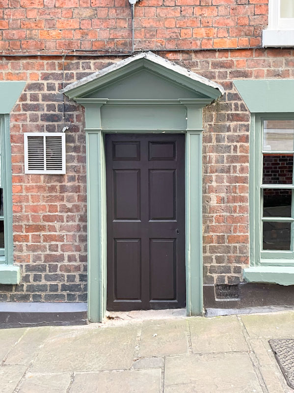 Black door on townhouse with grey portico, Claremont Hill, Shrewsbury, Shropshire, April 2025