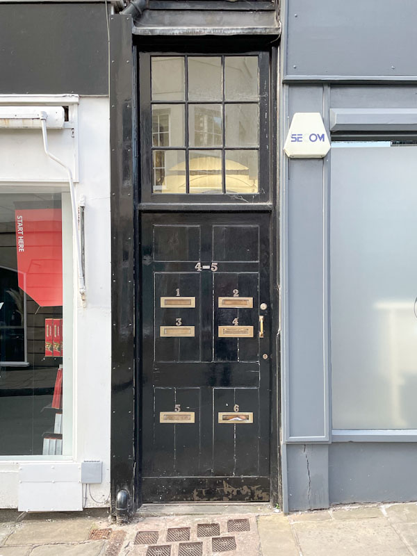 Black door to flats 4 and 5 with six letterboxes, Market Street, Shrewsbury, Shropshire, April 2025