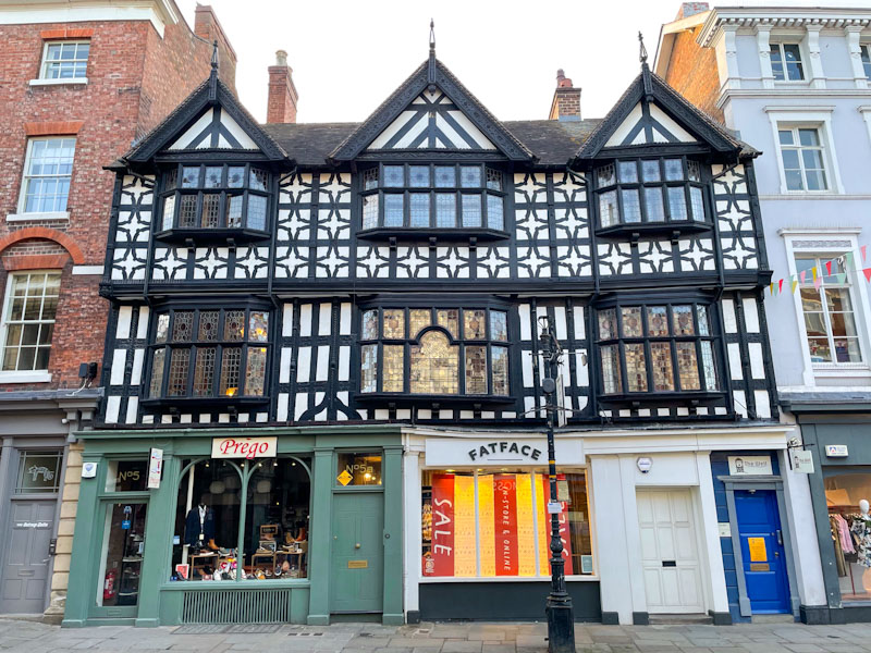 An array of doors beneath a stunning timber framed building, The Square, Shrewsbury, Shropshire, April 2025