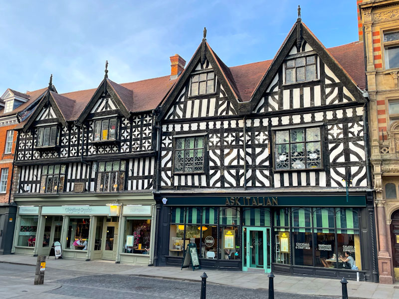 Shop doors on two beautiful timber framed buildings, The Square, Shrewsbury, Shropshire, April 2025