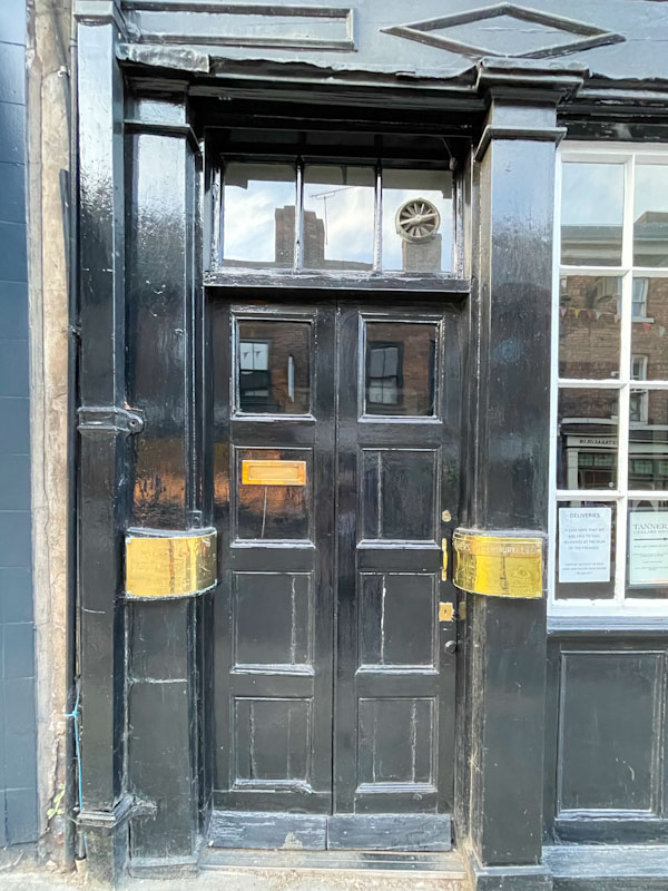 Black door and brass plates, Wyle Cop, Shrewsbury, Shropshire, England, April 2025