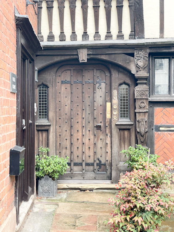 Close up of studded unpainted door and timber frame - note the letterbox in sited in the brickwork to the right of the door, Dogpole, Shrewsbury, Shropshire, August 2026