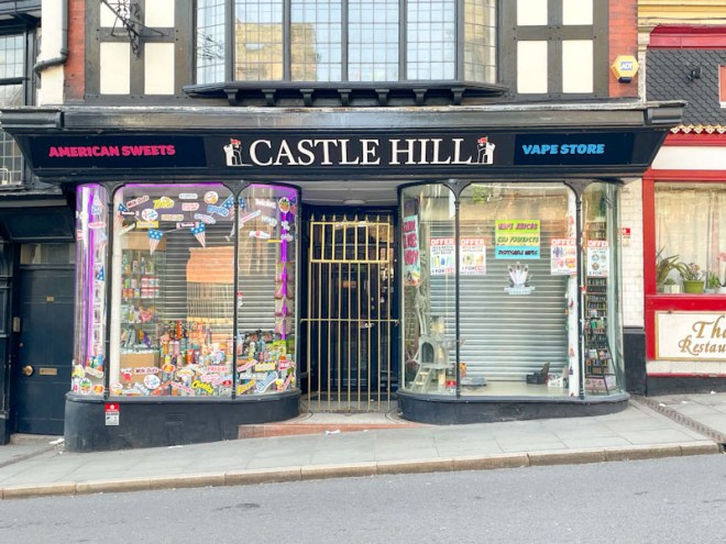 Double fronted shop windows either side of a gated door, Castle Gate, Shrewsbury, Shropshire, England, April 2025