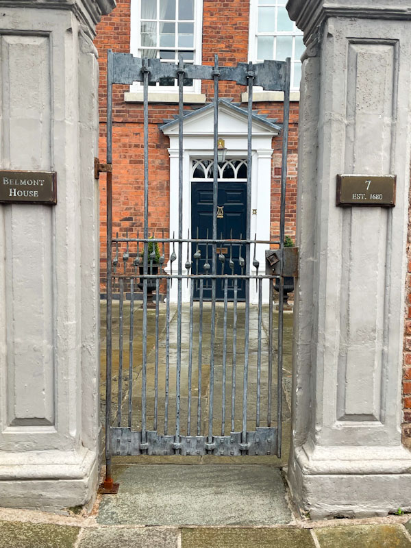 Through a gate to a blue door with portico, Belmont, Shrewsbury, Shropshire, England, August 2025