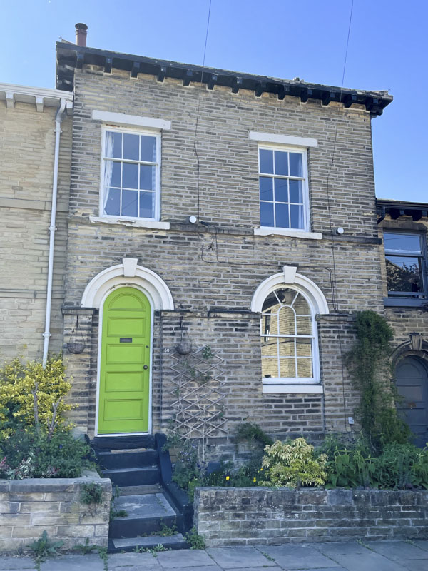 Green door in a larger house, George Street, Saltaire, West Yorkshire, England, May 2025