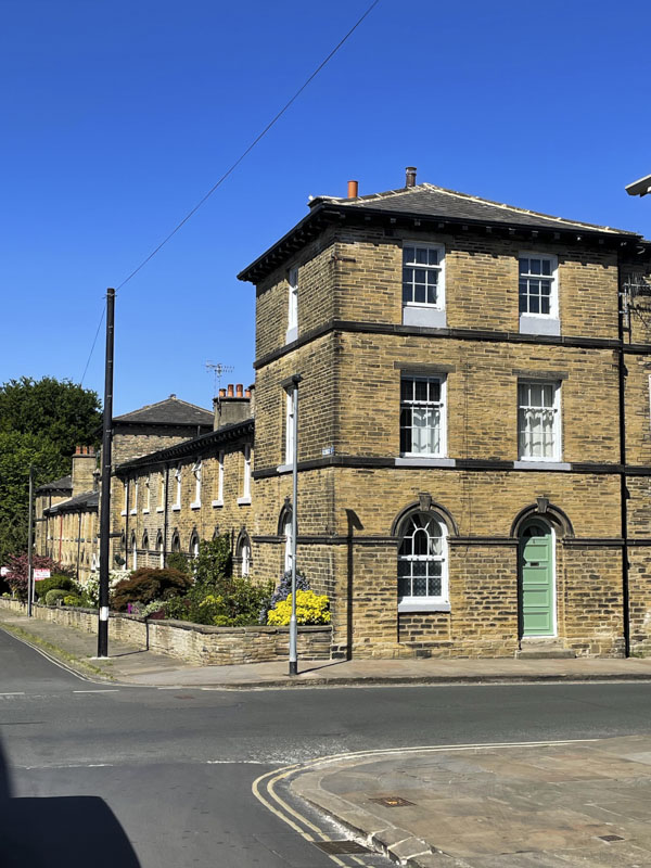 Three storey building and green door, George Street, Saltaire, West Yorkshire, England, May 2025