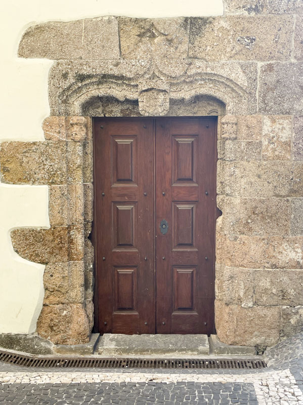 unpainted doors and old stone surround, Rua da Alfandega, Funchal, Madeira, Portugal, September 2025